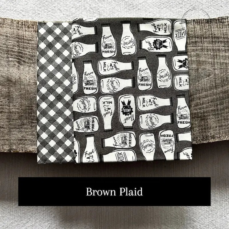 Fabric options for this sewing kit featuring a brown plaid pattern.