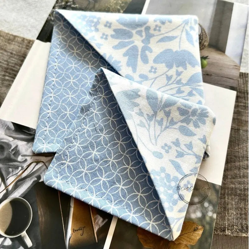 The corner bookmarks, made from this sewing pattern, are lying on top of a book.
