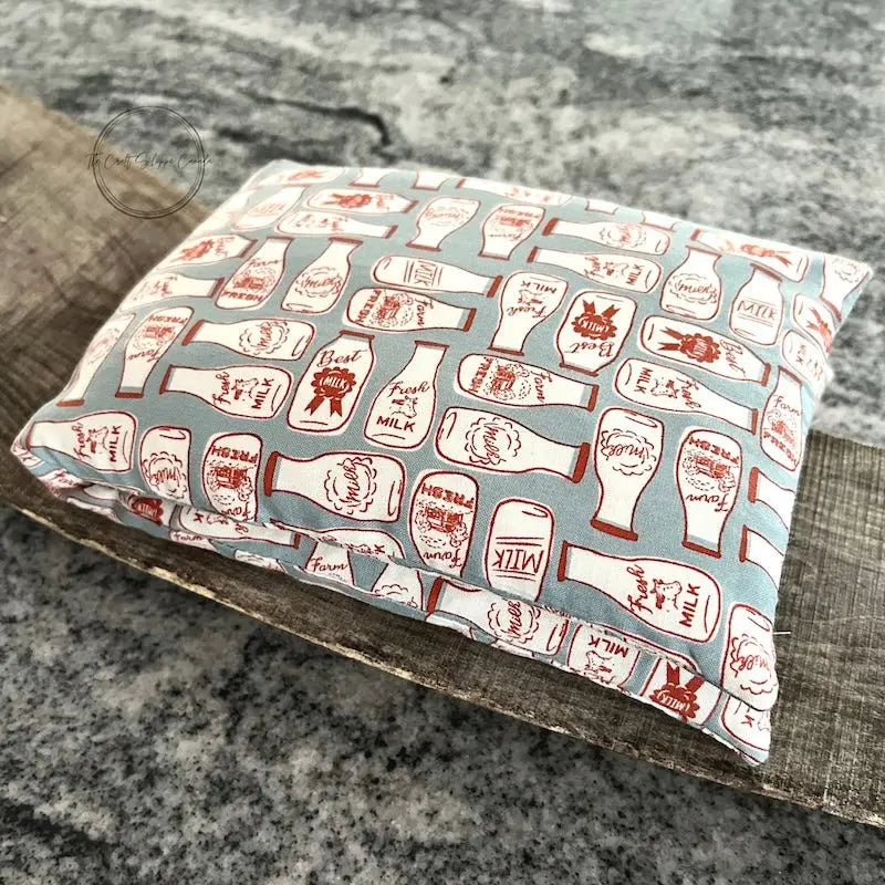 The rice bag heading pad, made from this sewing pattern, is folded on top of a wooden board.