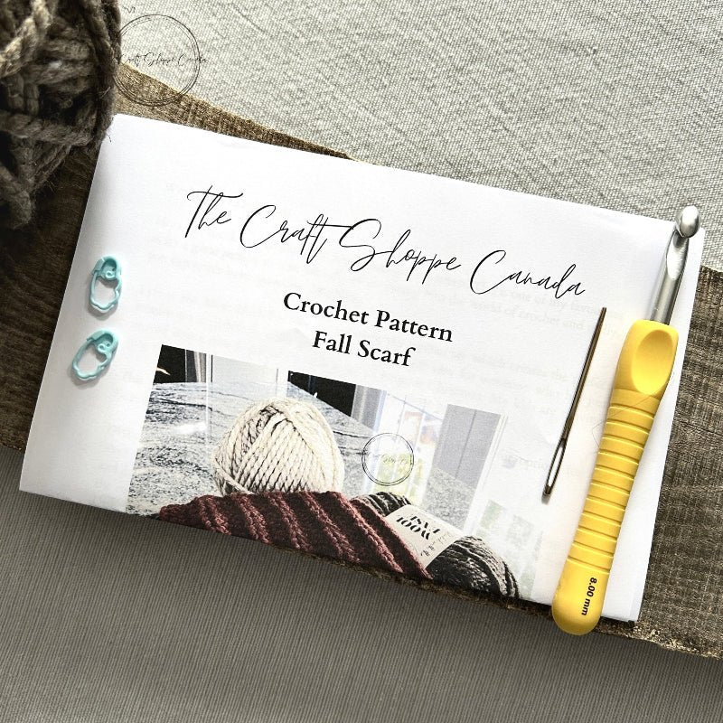 A copy of the scarf pattern with a crochet hook, ball of yarn, a tapestry needle and 2 stitch markers - The Craft Shoppe Canada
