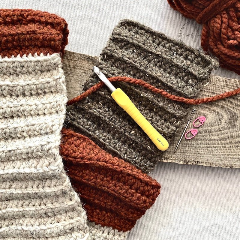 The finished scarf along with the yarn and crochet hook that is included in this crochet kit - The Craft Shoppe Canada