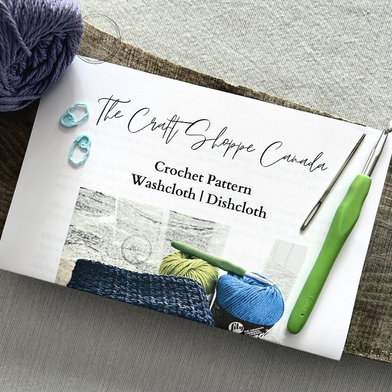 A copy of the dishcloth pattern with a crochet hook, ball of yarn, a tapestry needle and 2 stitch markers - The Craft Shoppe Canada