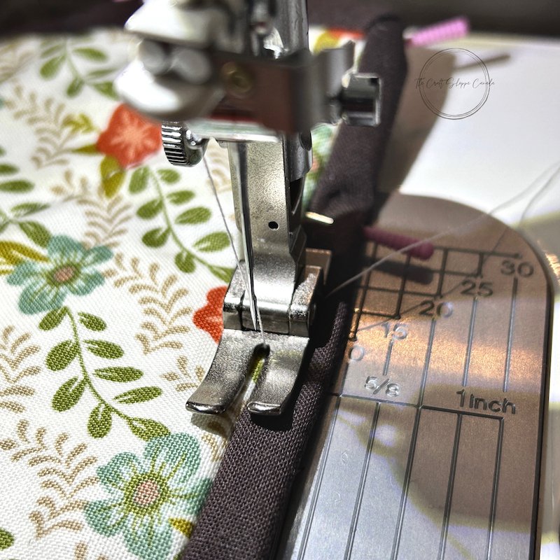 The hot pad underneath the needle on the sewing machine. The border is being sewn on. - The Craft Shoppe Canada