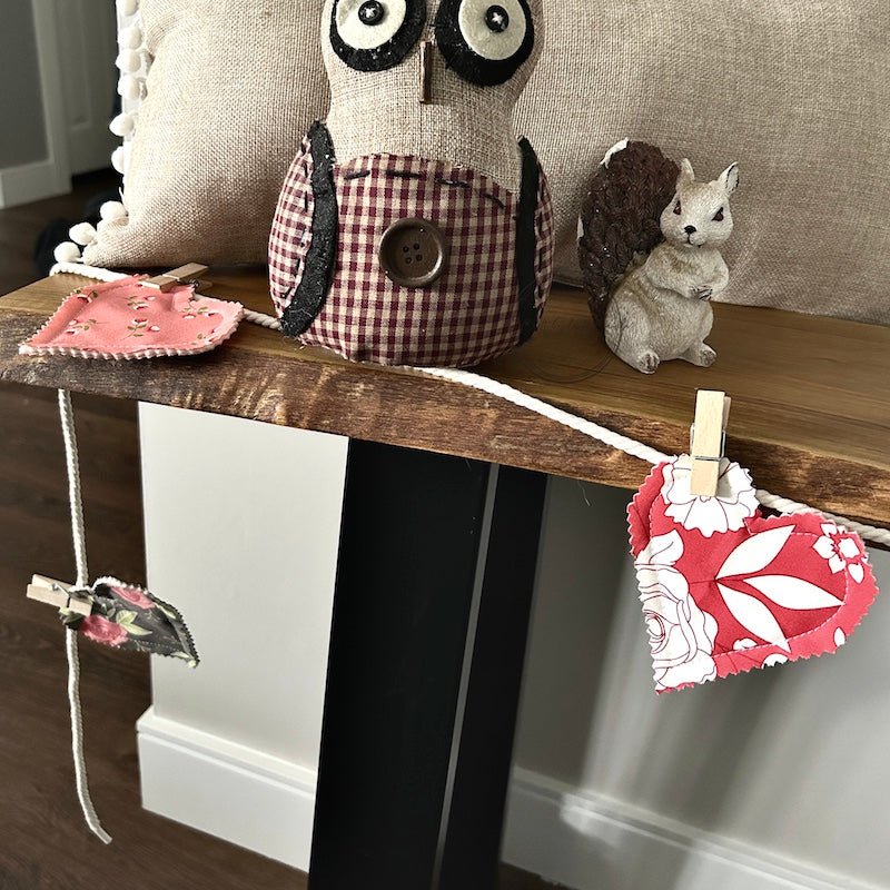 Finished hearts hanging on the garland with clothespins. The garland is laying on a table - The Craft Shoppe Canada