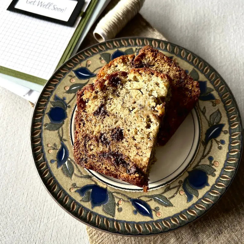 A piece of banana bread beside a card making kit