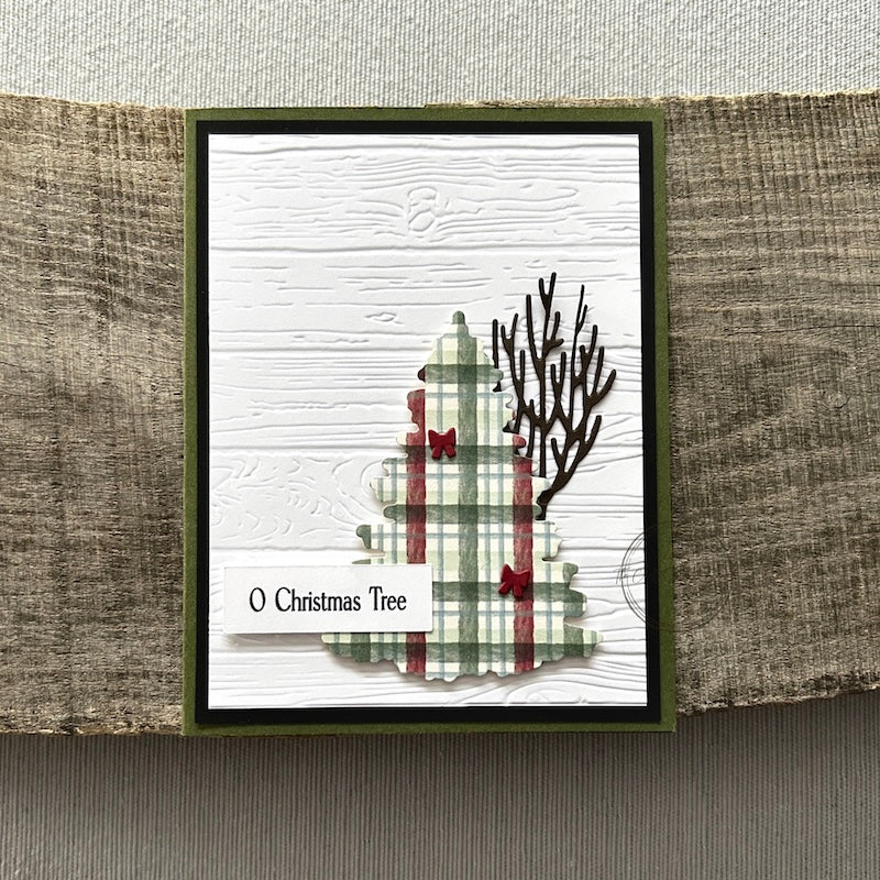 A finished card, from this card making kit, sitting on a wooden board.