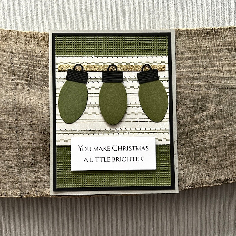 A finished card, from this card making kit, sitting on a wooden board.