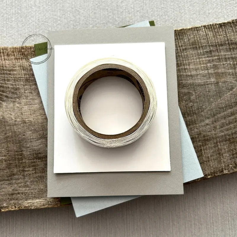 A roll of glue dots and a sheet of pop dots are sitting on a few blank cards. They are included in your card making kit.