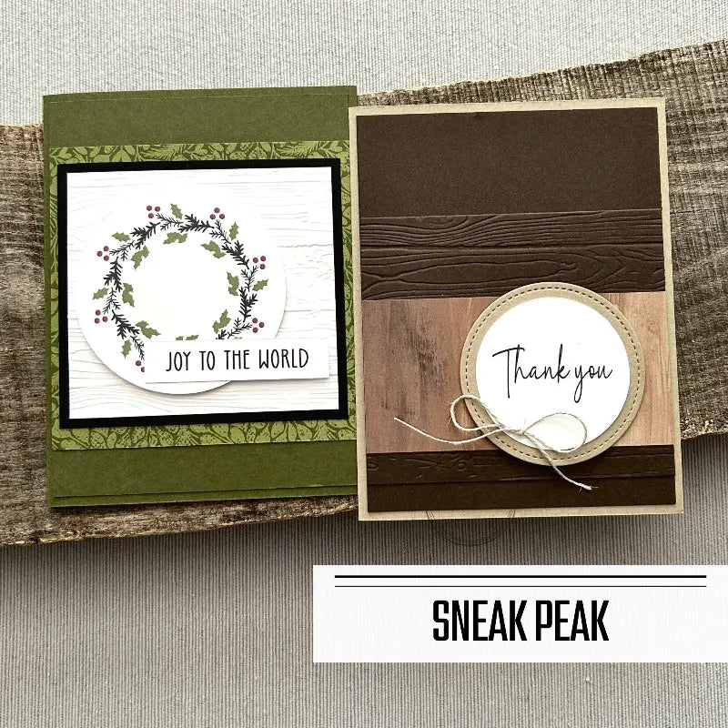 2 of the finished cards, from this card making kit, are sitting on a wooden board.