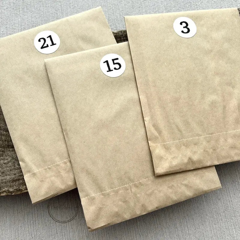 There are 3 numbered kits, that are included in the Advent Calendar, sitting on a wooden board.