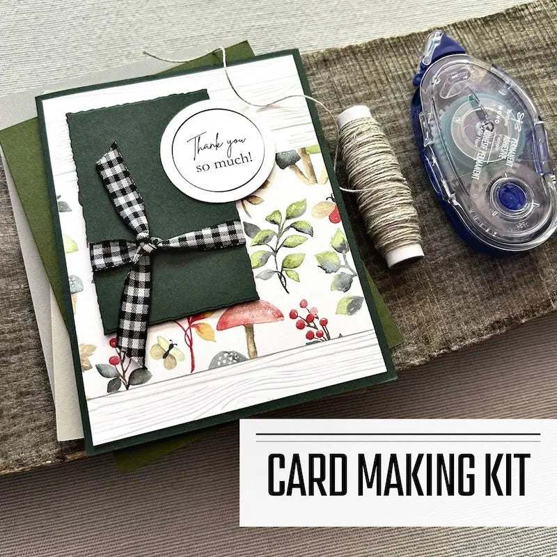 A DIY card making kit with assorted cards such as birthday, and thank-you et al. A finished card is sitting on blank cards with a roll of twine and a tape runner.