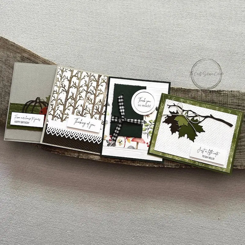 There are 4 finished cards, sitting on a wooden board, to show the finished cards that are included in this card making kit.