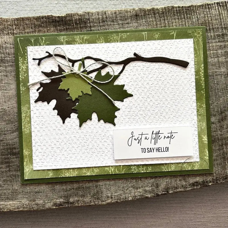 A finished card, from this card making kit, sitting on a wooden board.