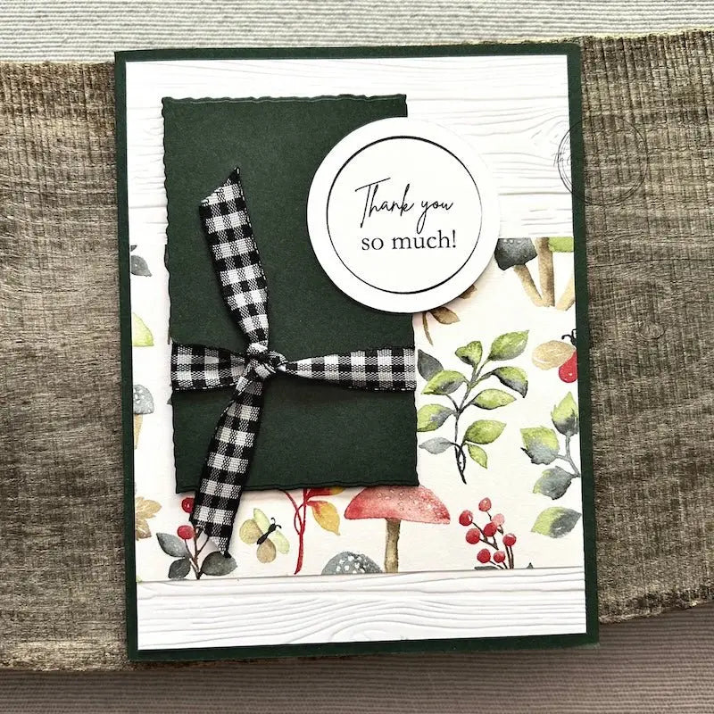 A finished card, from this card making kit, sitting on a wooden board.