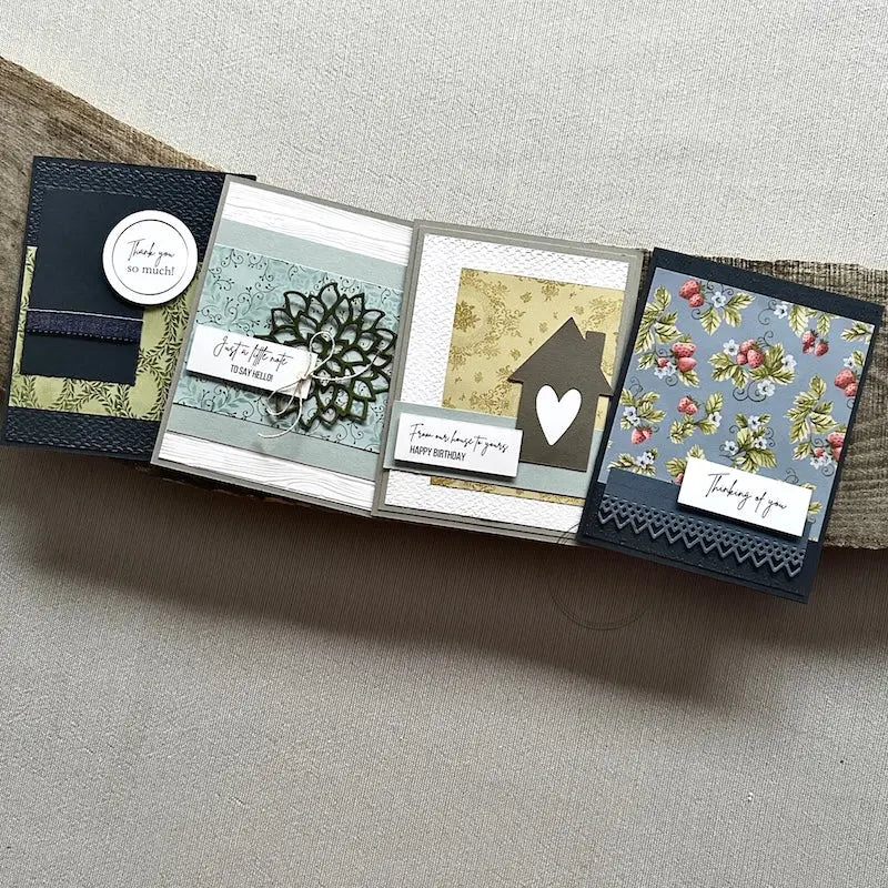 There are 4 finished cards, sitting on a wooden board, to show the finished cards that are included in this card making kit.