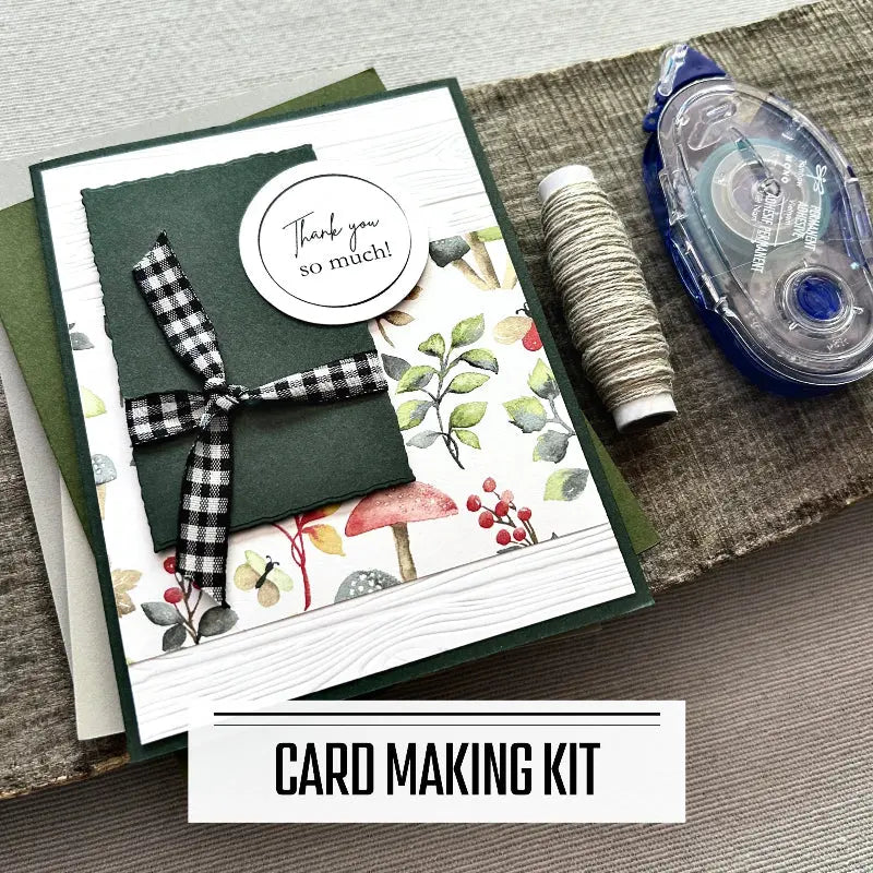 A DIY card making kit with assorted cards such as birthday, and thank-you et al. A finished card is sitting on blank cards with a roll of twine and a tape runner.