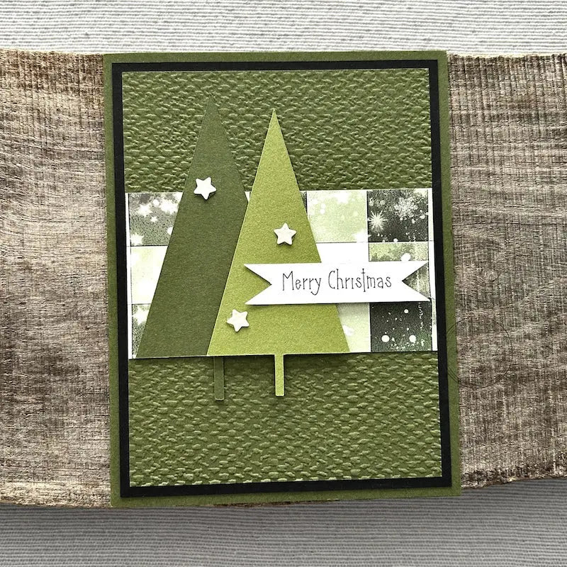 A finished card, from this card making kit, sitting on a wooden board.