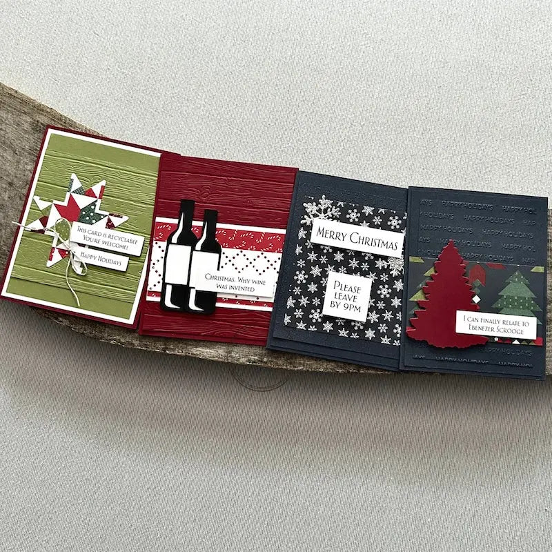 There are 4 finished cards, sitting on a wooden board, to show the finished cards that are included in this card making kit.