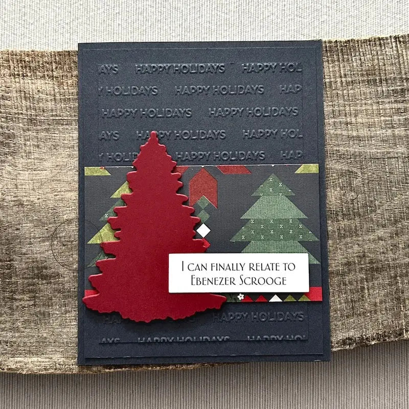 A finished card, from this card making kit, sitting on a wooden board.