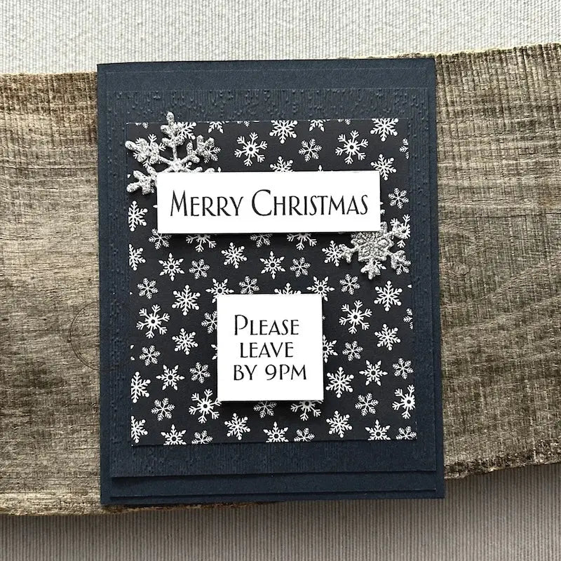 A finished card, from this card making kit, sitting on a wooden board.