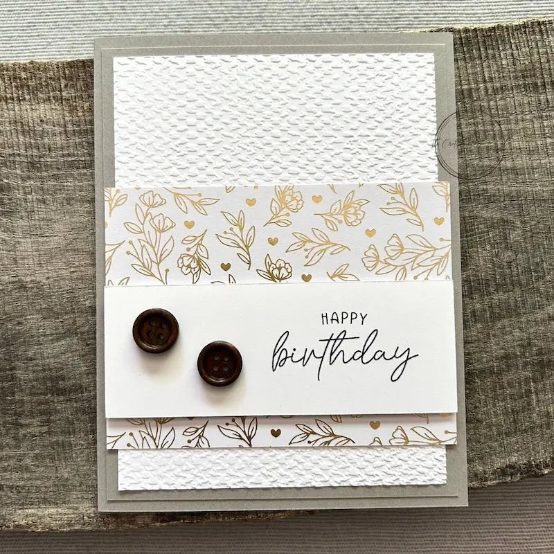 A finished card, from this card making kit, sitting on a wooden board.