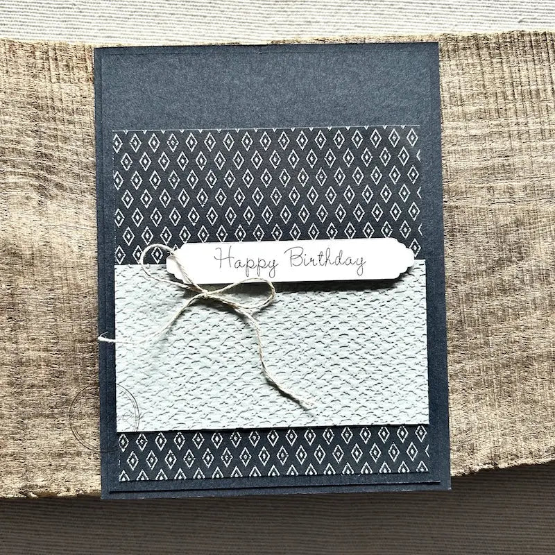 A finished card, from this card making kit, sitting on a wooden board.
