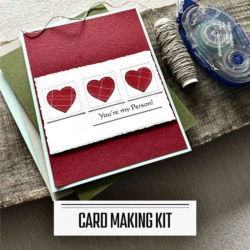 A DIY card making kit for Valentine's Day, wedding and anniversaries. A finished card is sitting on blank cards with a roll of twine and a tape runner.