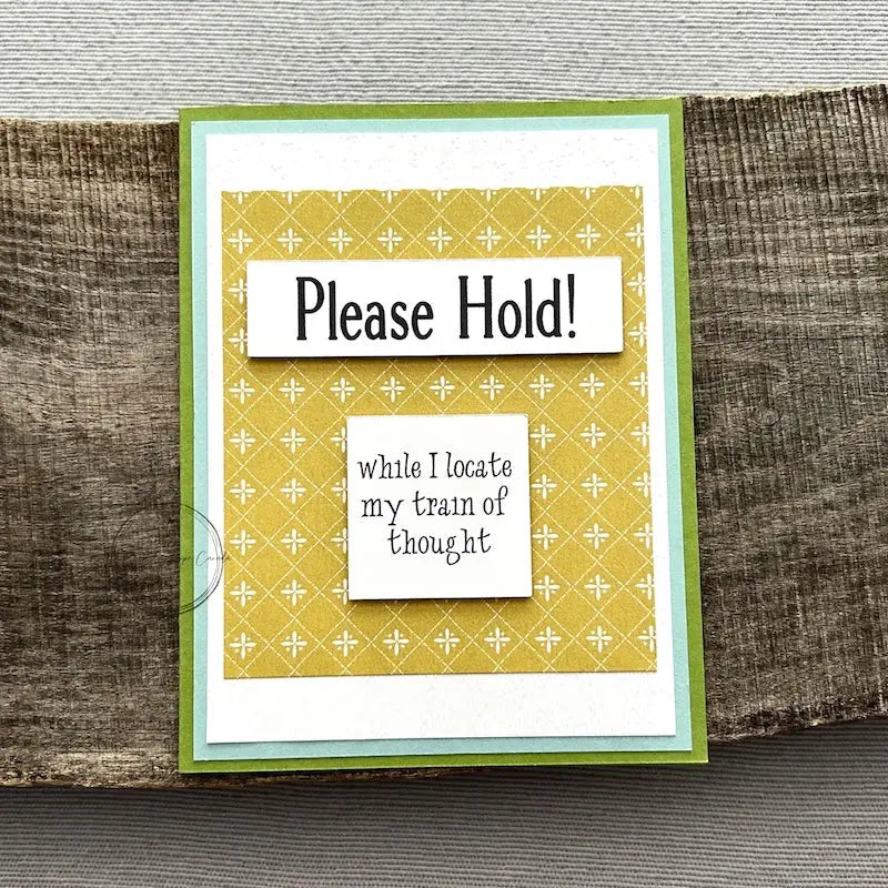 A finished card, from this card making kit, sitting on a wooden board.
