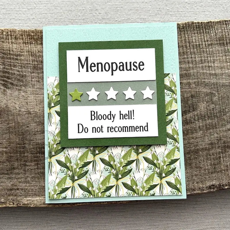 A finished card, from this card making kit, sitting on a wooden board.