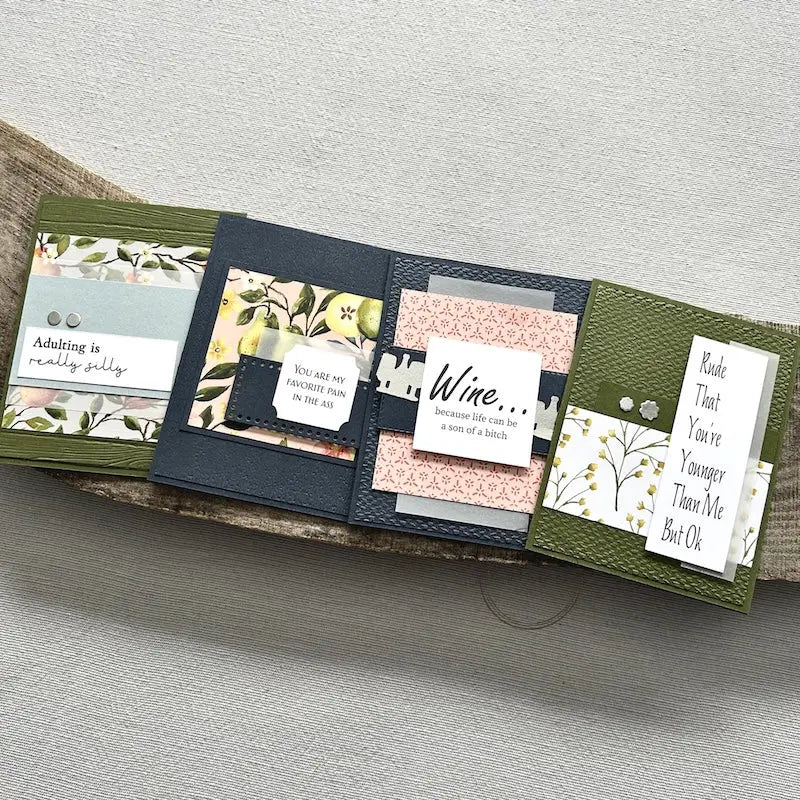 There are 4 finished cards, sitting on a wooden board, to show the finished cards that are included in this card making kit.