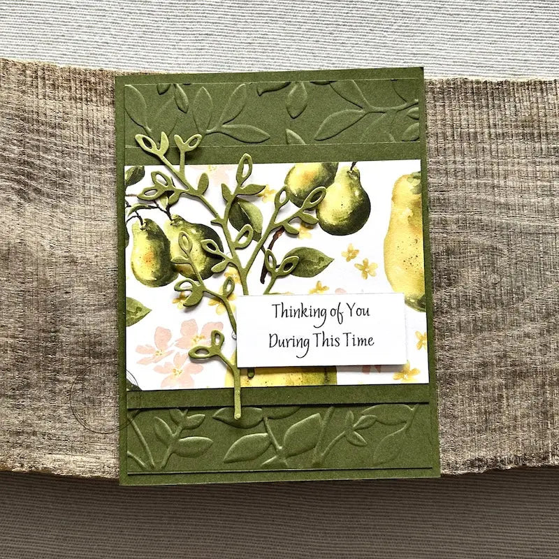 A finished card, from this card making kit, sitting on a wooden board.