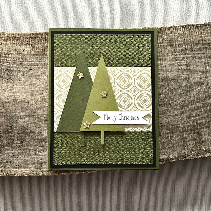 A finished card, from this card making kit, sitting on a wooden board.