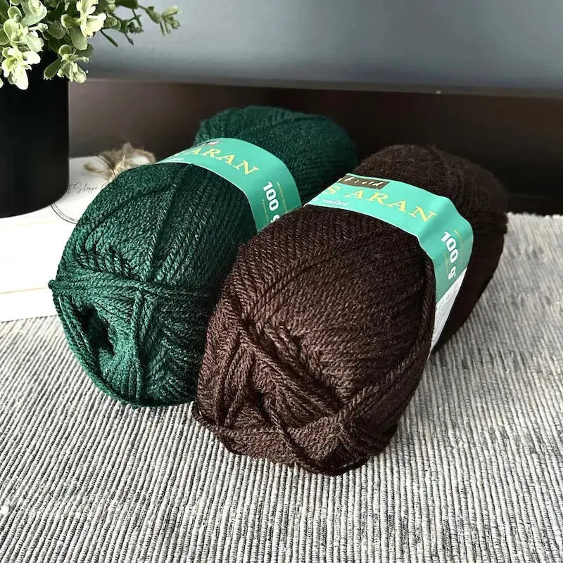 The green and brown yarn, that would be used with this crochet kit, is sitting on a table.