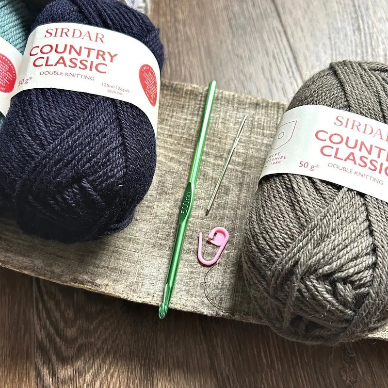 A close of the crochet hook, tapestry needle and stitch marker used in this crochet kit.