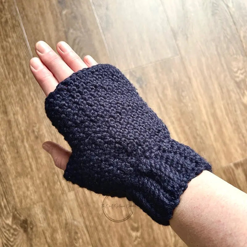 A look at the finished mitten, made from this crochet kit, being worn on a hand.