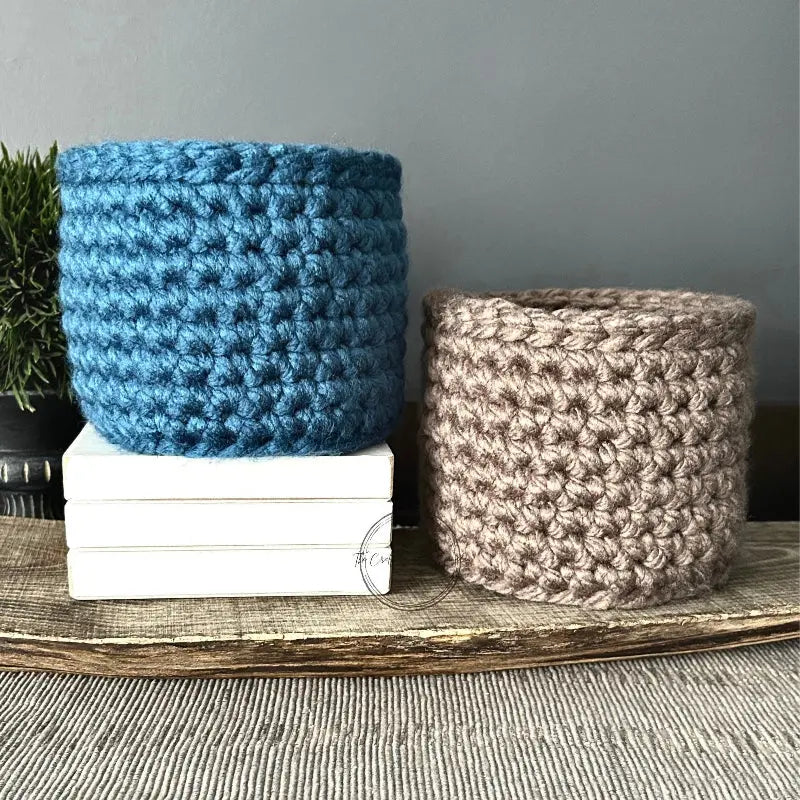 The storage basket, from this crochet kit, is sitting on a wooden board.