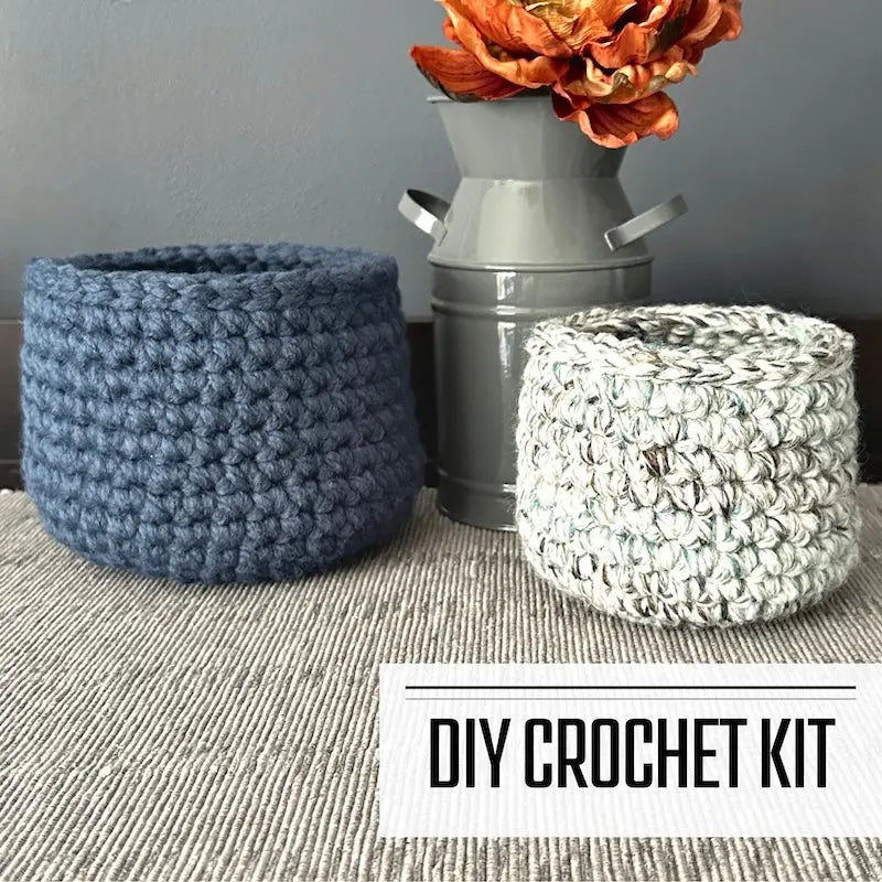 A crochet kit for a set of 2 storage baskets. The finished baskets are sitting on a table.