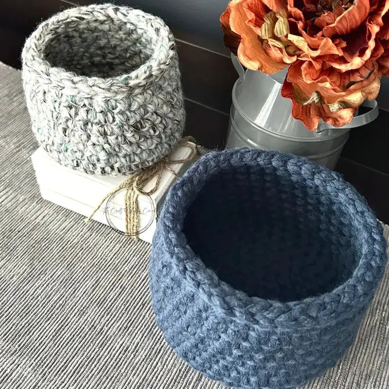 The storage baskets, from this crochet pattern, are sitting on a table where you can see what the insides look like.