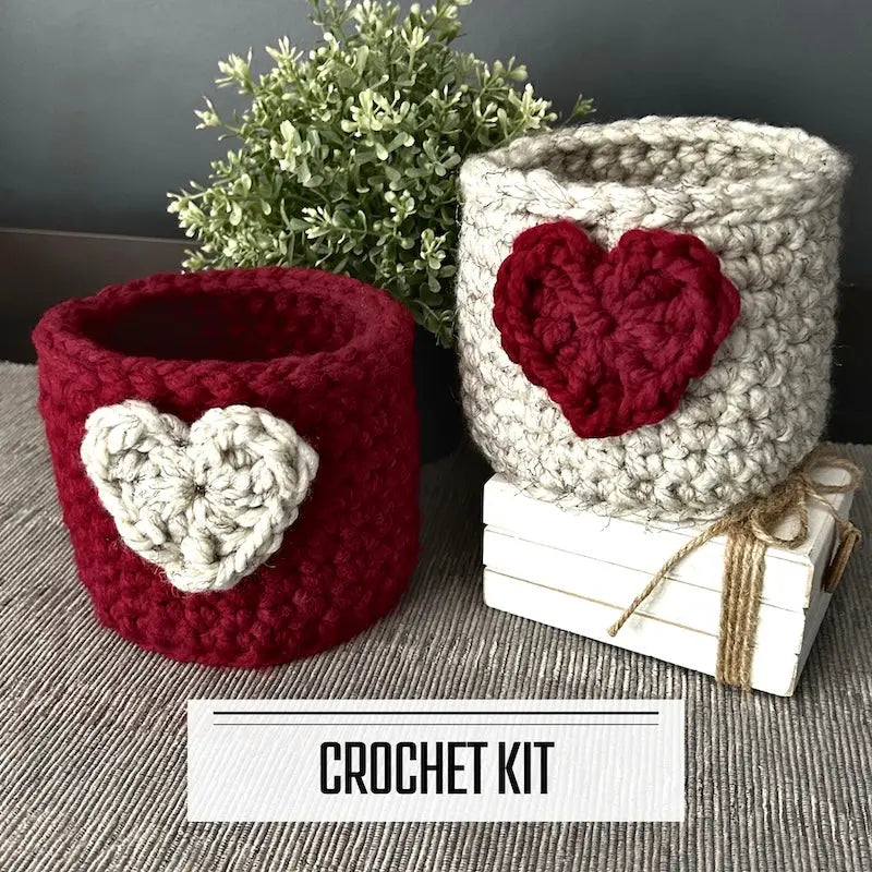 A crochet kit for a heart basket for Valentine's Day. The finished baskets are sitting on a table.