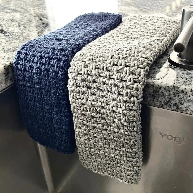 A close up of the finished washcloths, made from this crochet kit, draped over a sink.