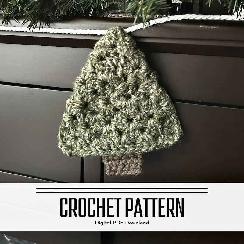 A DIY crochet pattern for a Christmas tree garland. The garland is hanging on off of a buffet with a pine garland on top.