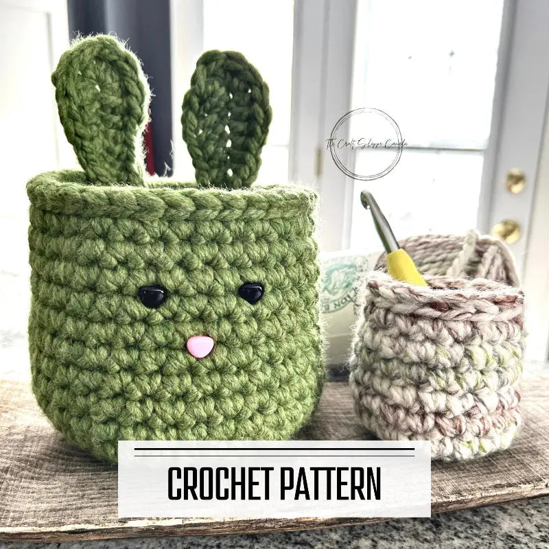 A digital PDF crochet pattern for an Easter bunny basket set. The baskets are sitting on a wooden board with yarn and a crochet hook.