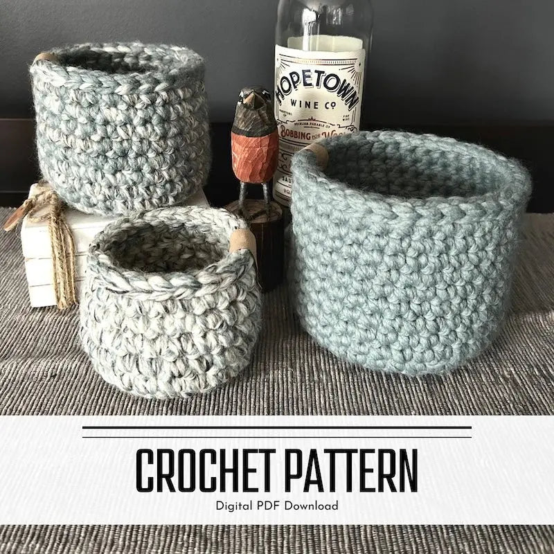 A digital PDF crochet pattern for a set of 3 storage baskets. The baskets are sitting on top of a buffet.