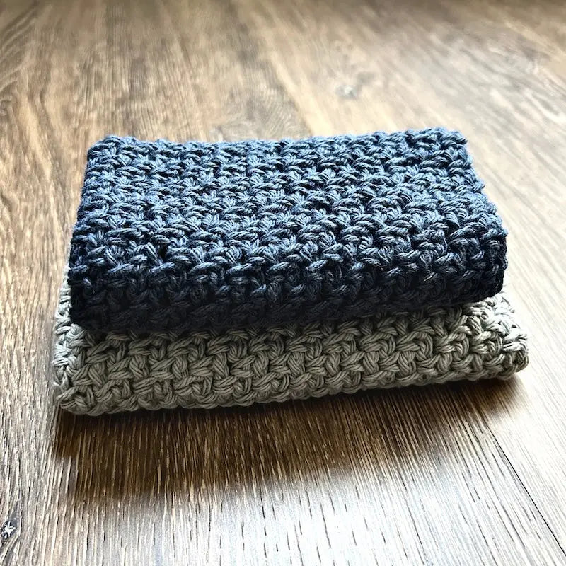 The finished washcloths, made from this crochet pattern, are sitting on the floor.