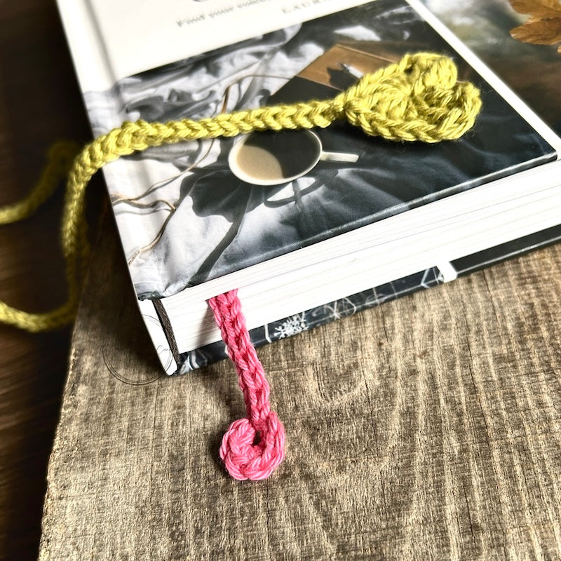 The finished bookmark, made from this crochet pattern, is peeking out the bottom of a book.