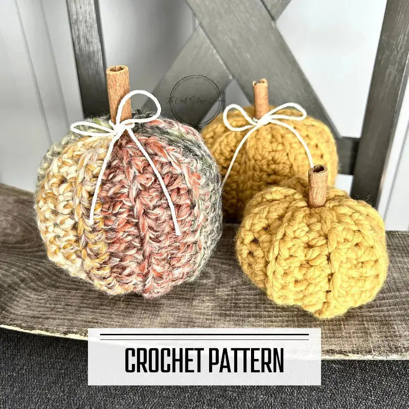 A digital PDF crochet pattern for a set of autumn pumpkins. The pumpkins are lying over a wooden table on a chair.