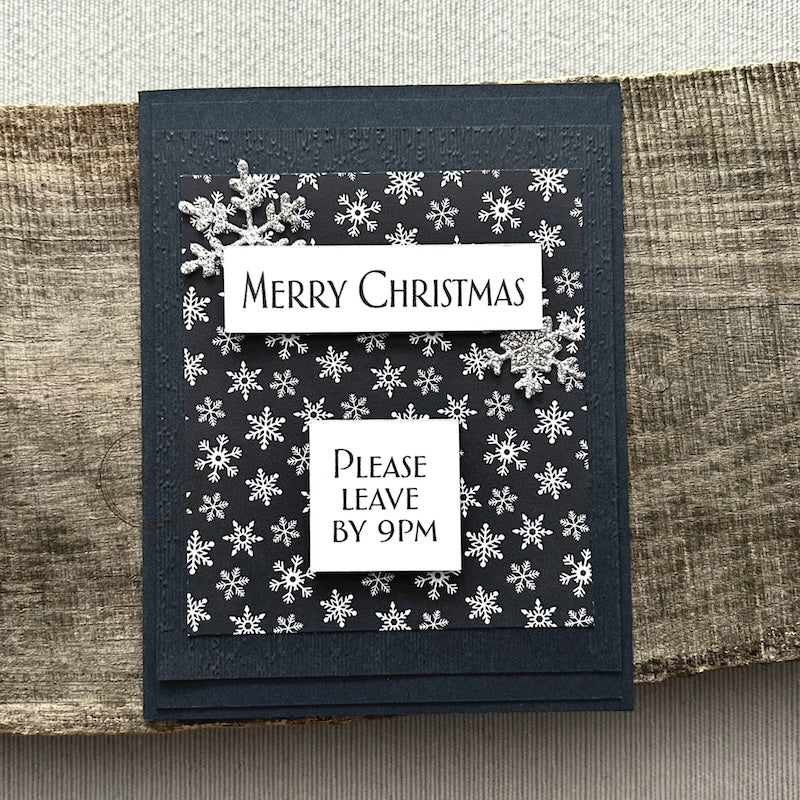 A finished card, from this card making kit, sitting on a wooden board.