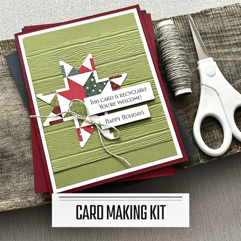 A DIY card making kit for Christmas. A finished card is sitting on blank cards with a roll of twine and scissors.