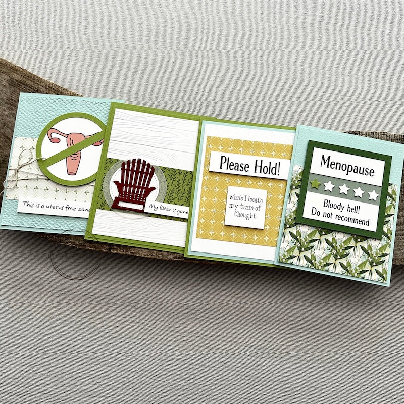There are 4 finished cards, sitting on a wooden board, to show the finished cards that are included in this card making kit.
