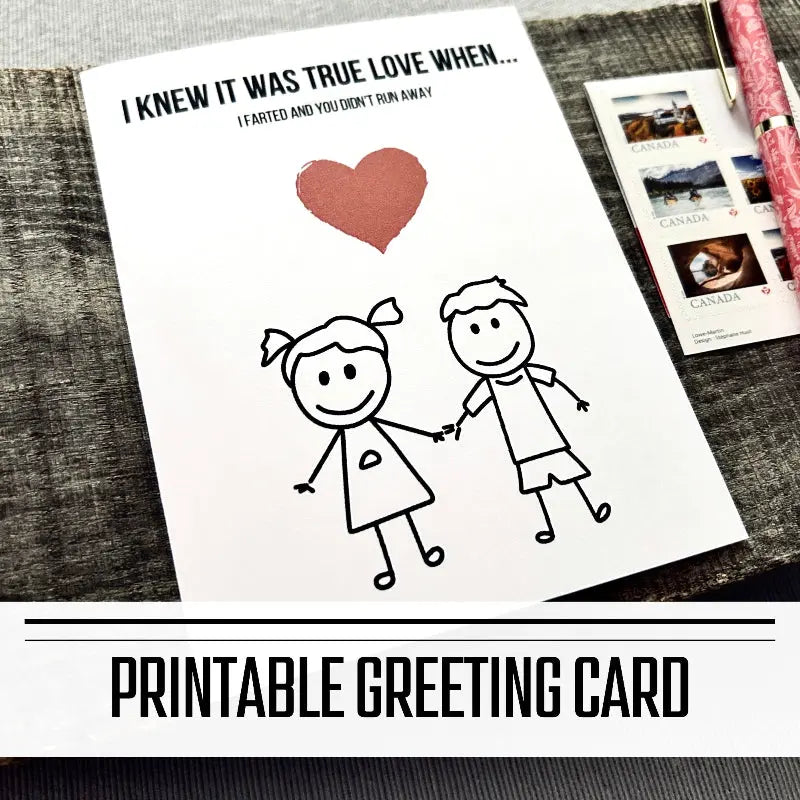 A printable greeting card for Valentine's or an anniversary. The finished card is sitting on a wooden board with a pen and stamps.